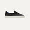 side | The Kids slip-on Sneaker in Black shown from a side view showing the outsole.