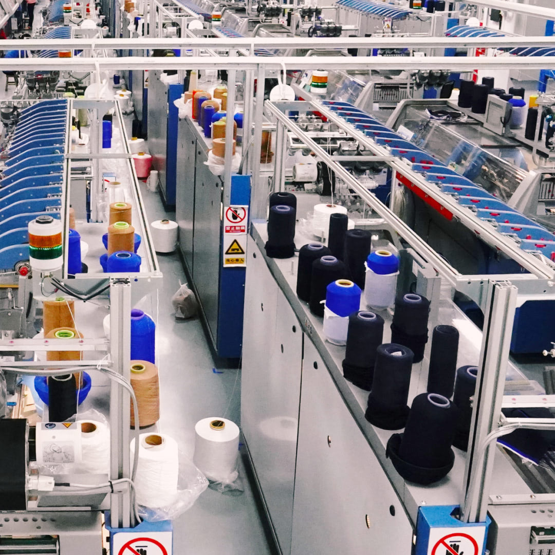 Factory interior with spools of thread on a conveyor belt