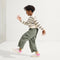 model | An alternate image of a child modeling The Kids Strap Sneaker in Pink Taffy. 