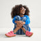 model | An alternate image of a child modeling The Kids Strap Sneaker in Watermelon. 