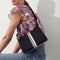 hover | The Casual Crossbody in Black & Ivory Stripe, worn over the shoulder by a model, shown from the side. 
