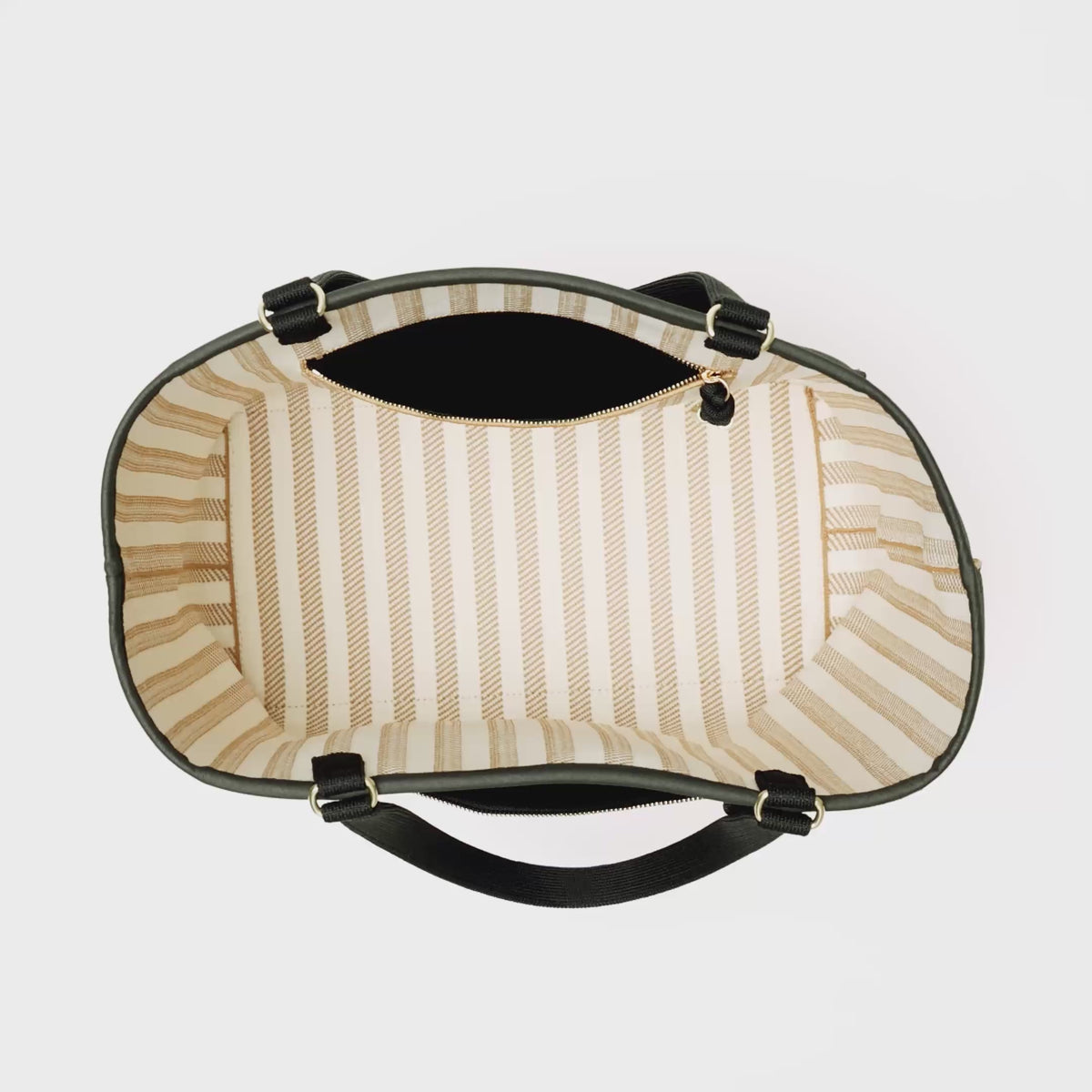 The Two-Way Tote in Sandbar is packed with a laptop, notebook, water bottle, a Petite Pouch and a deck of cards. In the interior pocket, small toiletries and a pair of sunglasses are added, and is then zipped closed. An iPhone is also zipped into the outer pocket. The model ties a scarf around the handle and carries the bag out of frame. 