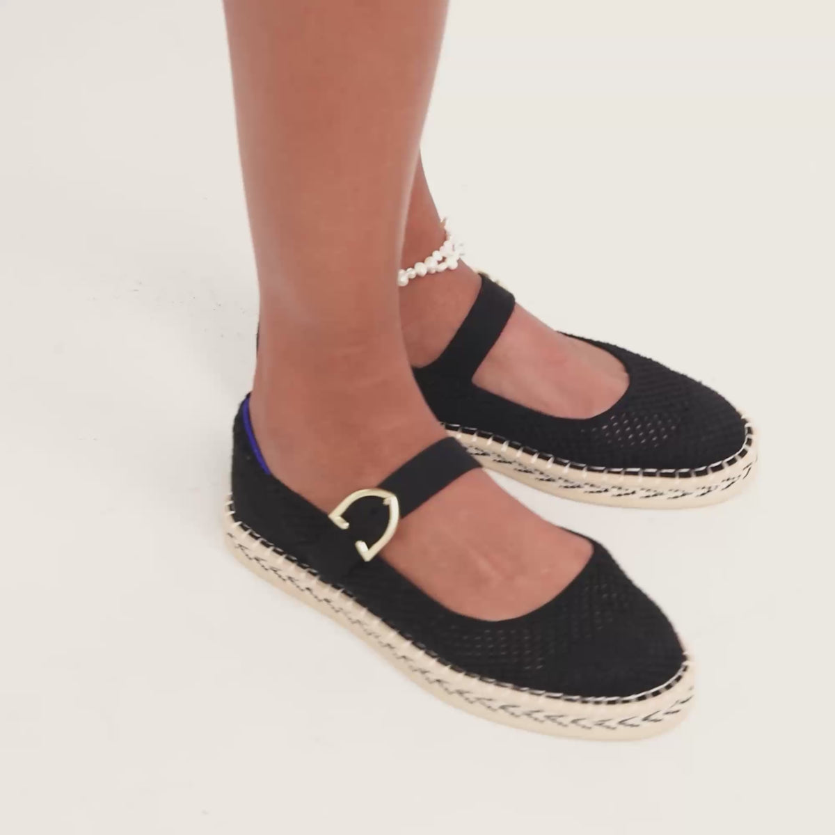 Model moving around in The Espadrille Mary Jane in Black, showing different angles of the shoe. 